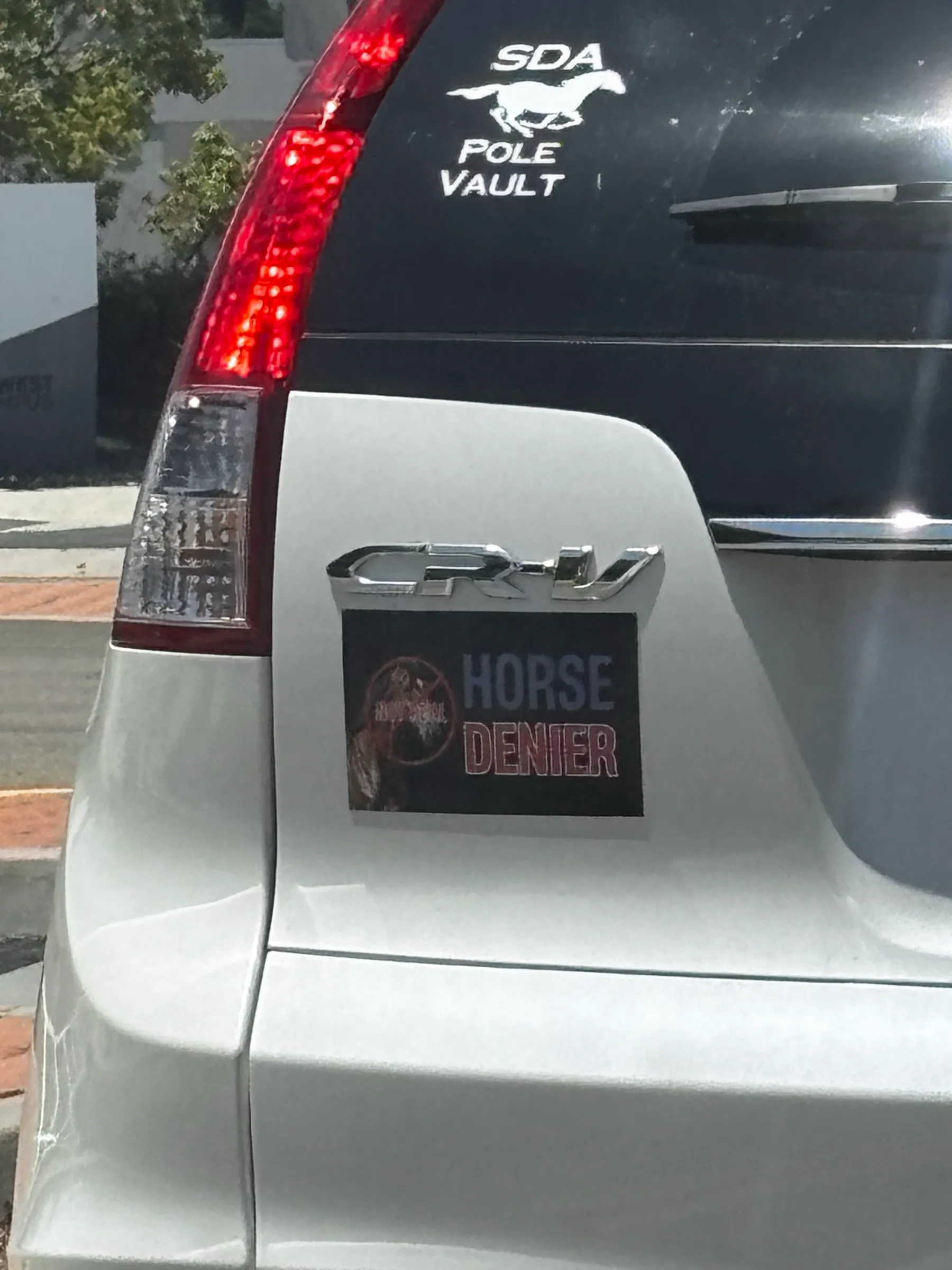 A magnet on the back of a Honda CR-V that reads HORSE DENIER