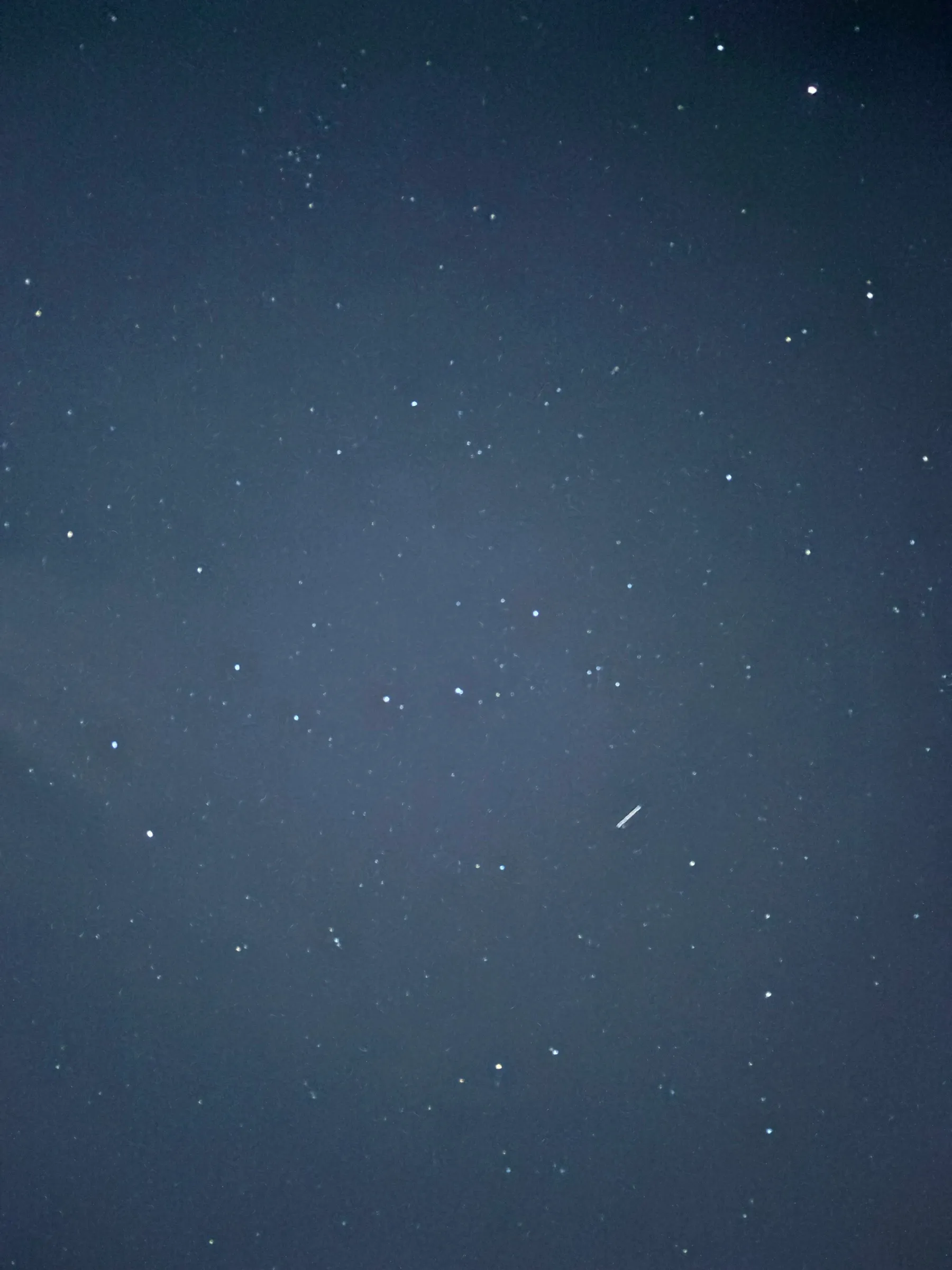 A starry night sky with a faint shooting star