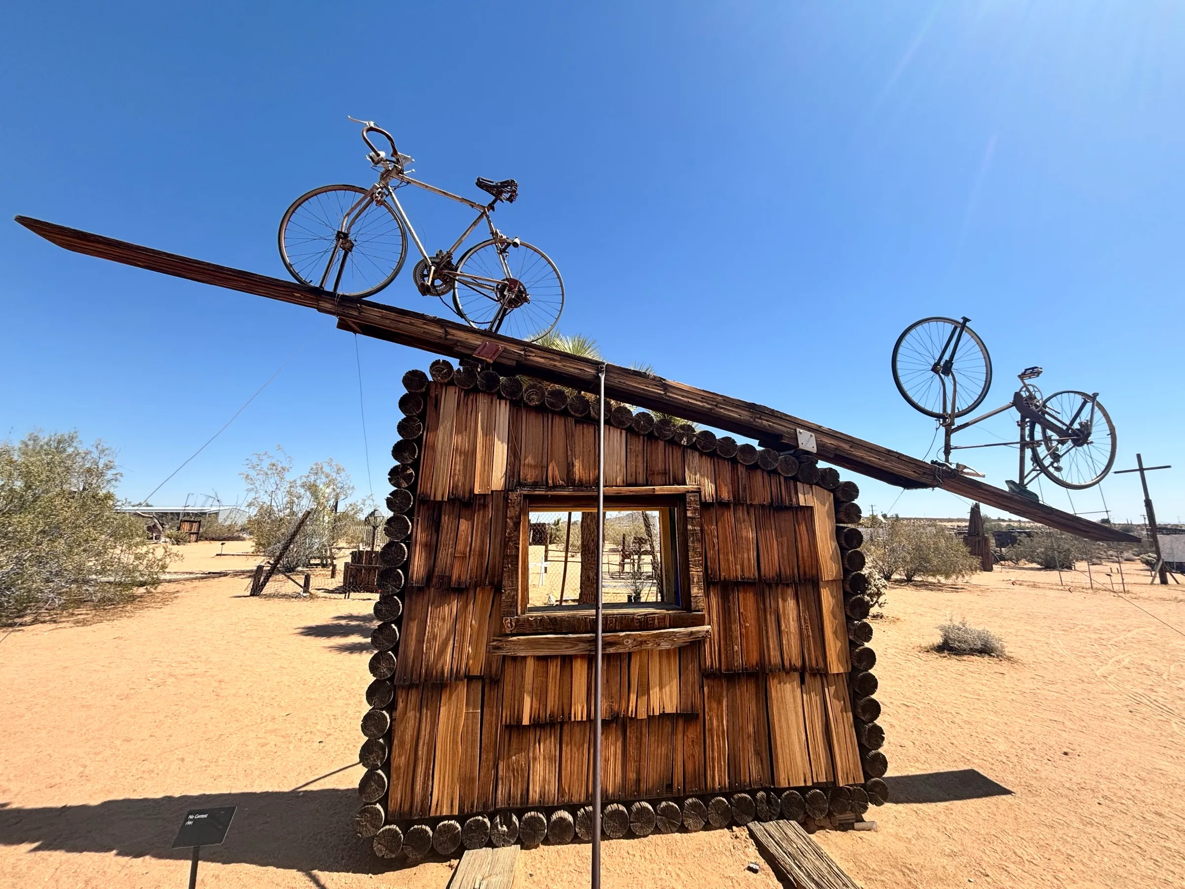 Bicycles mounted on a wooden cabin sculpture in the desert