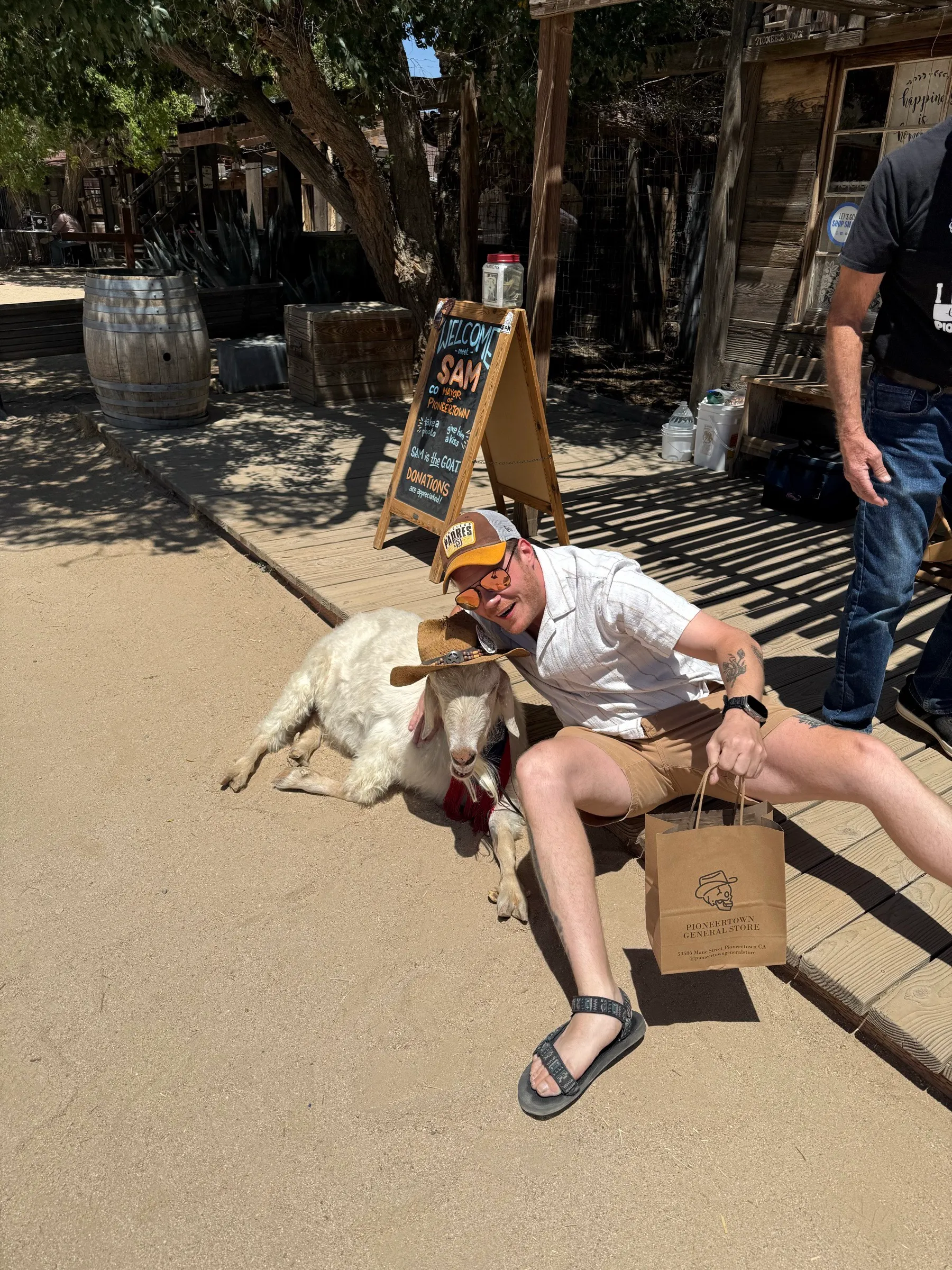 Posing with Sam, a goat in a cowboy hat, in Pioneertown