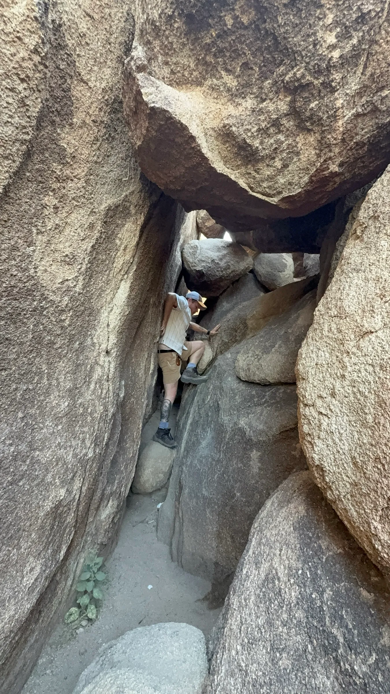 Climbing down through a passage between huge boulders