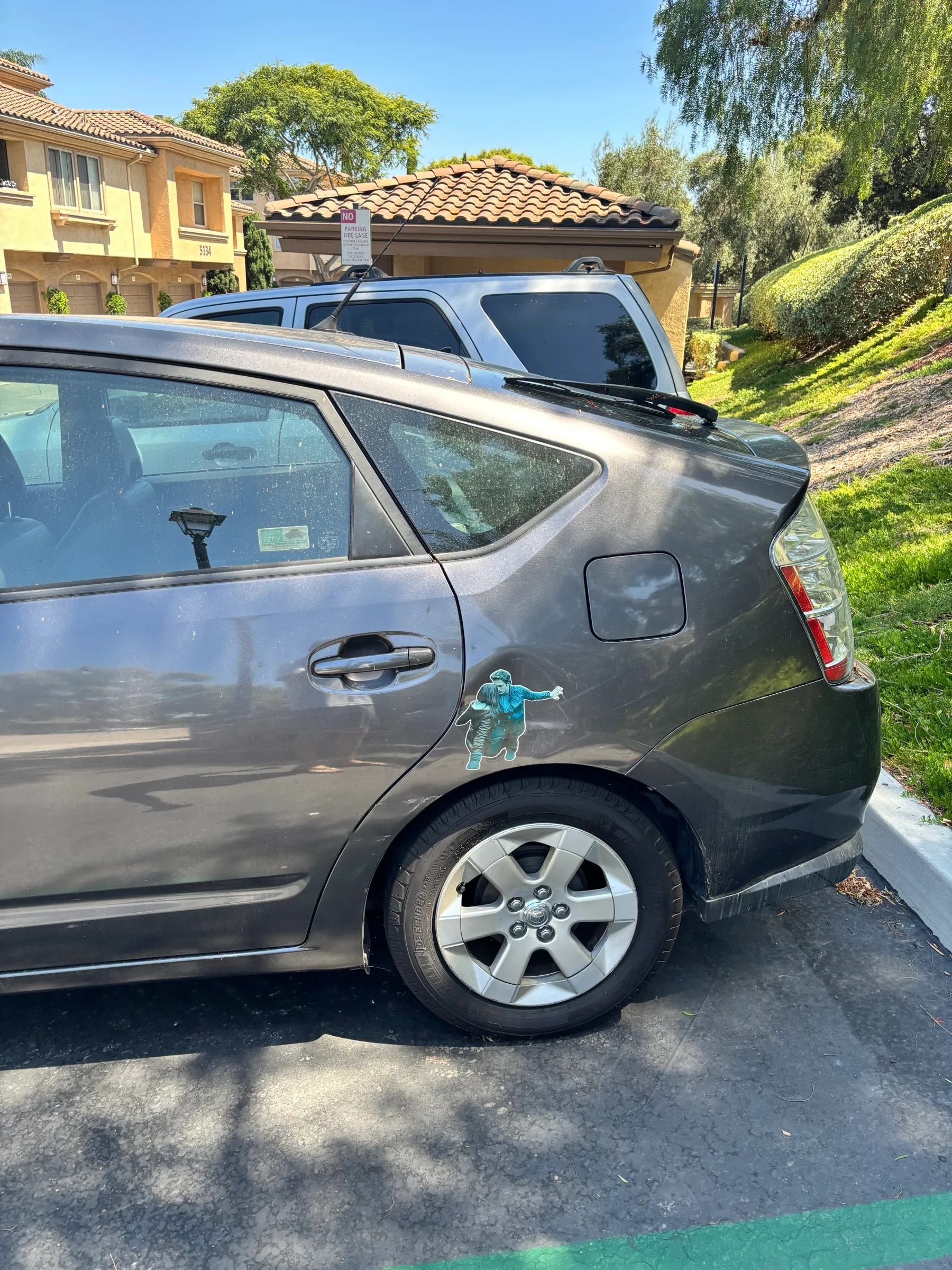 A gray Prius with a Twilight decal of Edward and Bella on the rear panel
